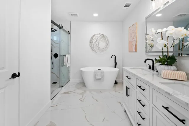 a bathroom with a double vanity sink mirror and shower
