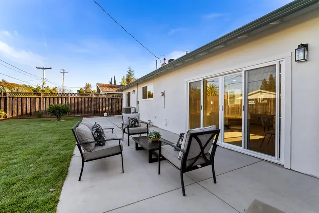 a backyard of a house with table and chairs