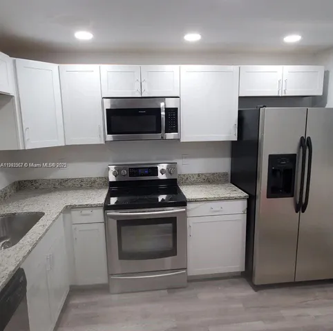 a kitchen with a sink stainless steel appliances and cabinets