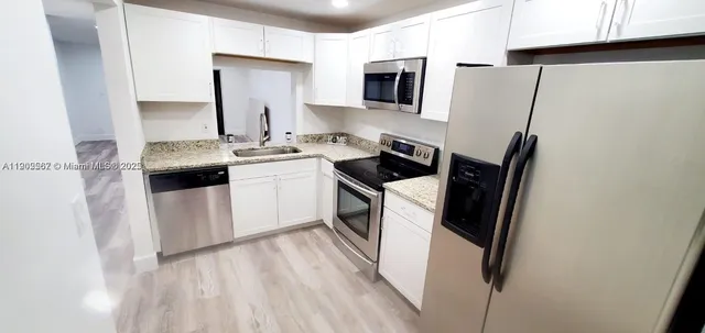 a kitchen with a sink appliances and cabinets