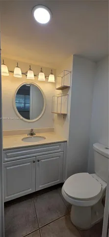 a bathroom with a toilet a sink and mirror