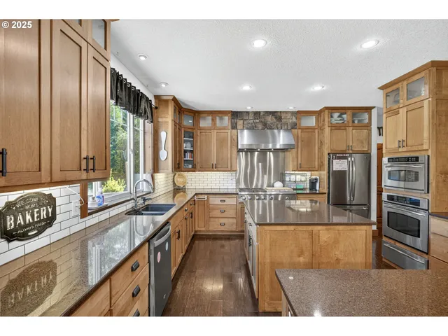a kitchen with counter top space a sink and stainless steel appliances