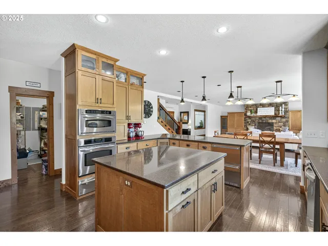a kitchen with stainless steel appliances granite countertop a sink a stove and a wooden cabinets