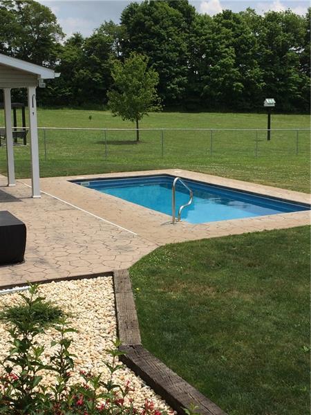 246 Burdette Road Stoneboro, PA 16153 - Photo 23 of 24 Fiberglass inground pool with a stamped stone covered patio.