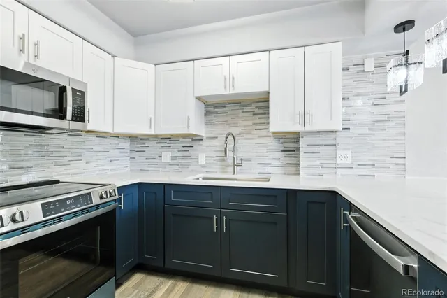 a kitchen with stainless steel appliances a stove microwave and sink