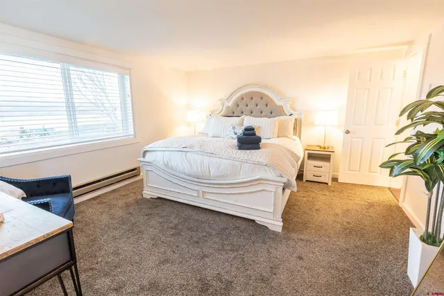 a bedroom with a bed and a potted plant next to a window