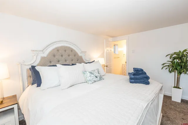 a bedroom with a bed and a potted plant