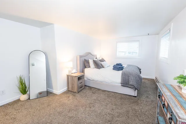 a bedroom with a bed and a painting on the wall