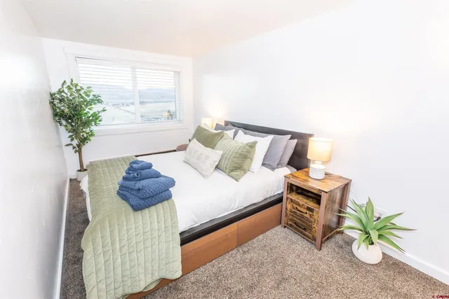 a bed sitting in a bedroom next to a window