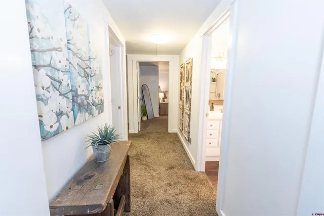 a view of a hallway with wooden floor and a living room