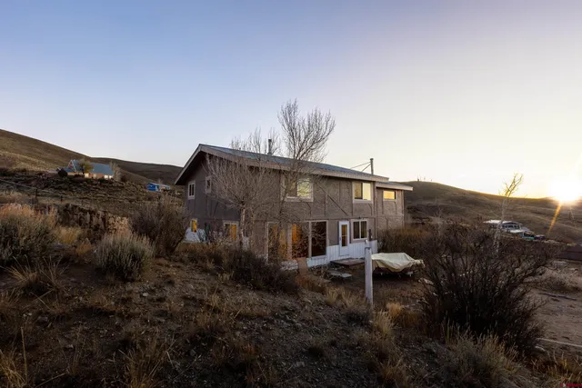 a view of a house with a yard and fence