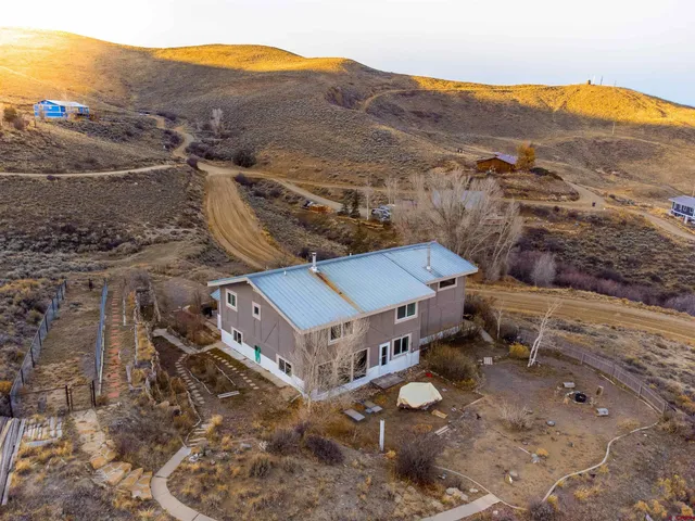 an aerial view of a house with a mountain