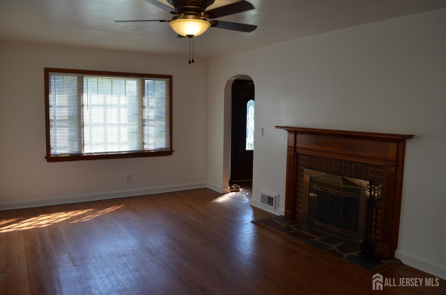 550 4th Street Dunellen, NJ 08812 - Photo 26 of 30 an empty room with wooden floor fan and windows