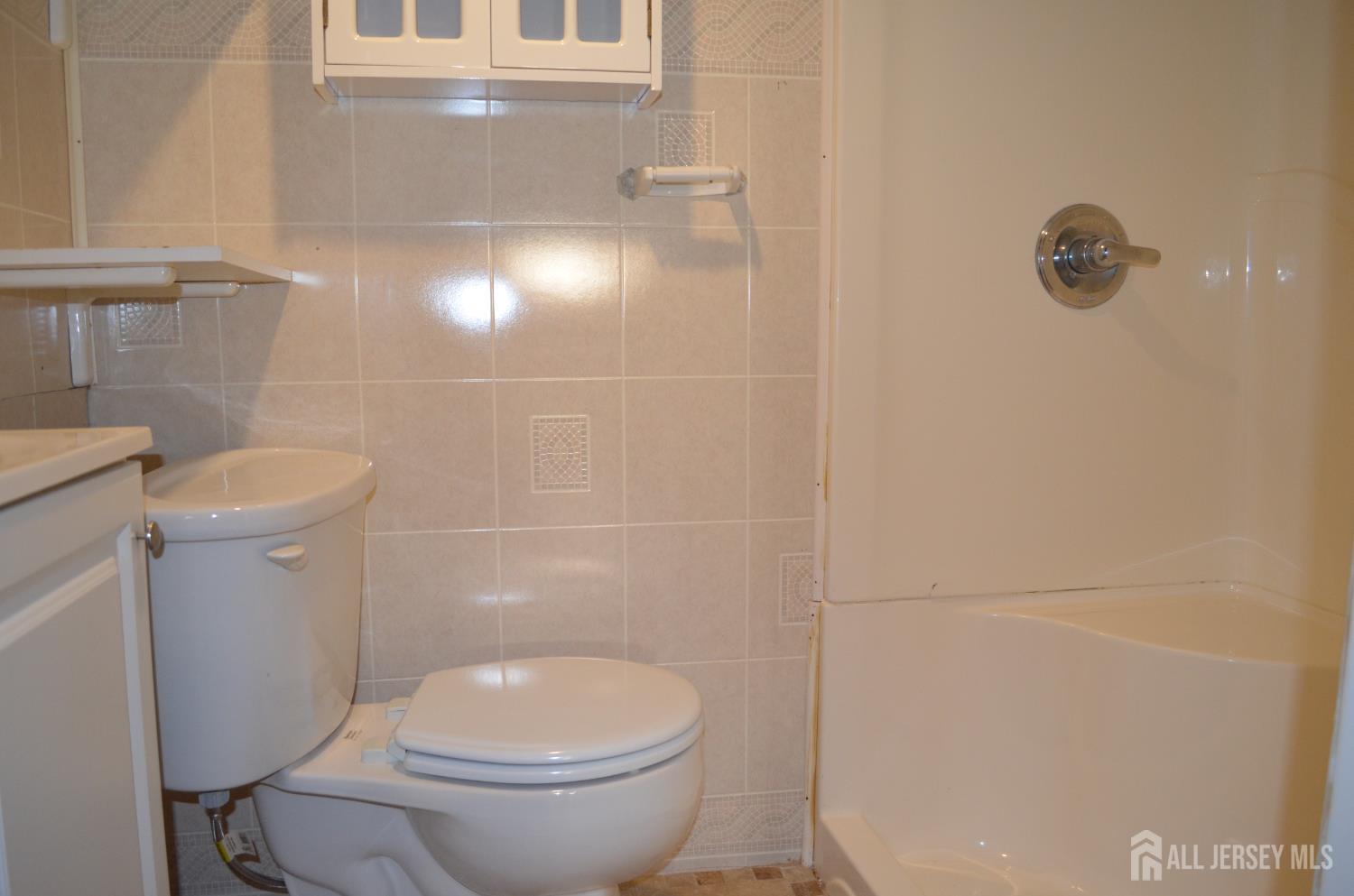 550 4th Street Dunellen, NJ 08812 - Photo 4 of 30 a white toilet sitting next to a bathroom sink