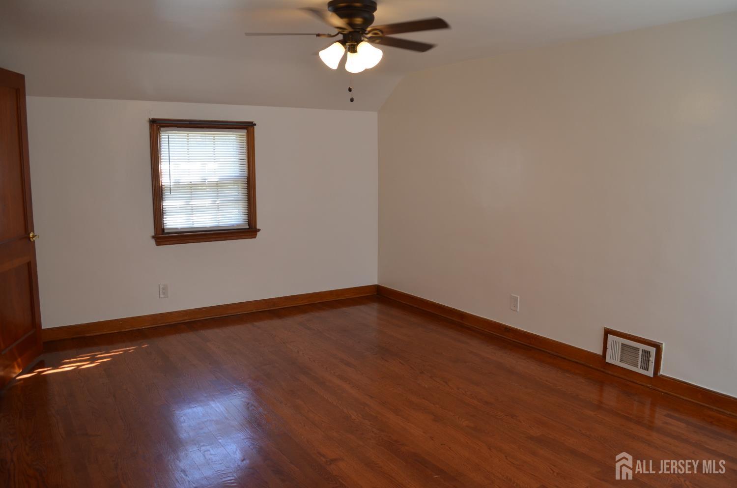 550 4th Street Dunellen, NJ 08812 - Photo 6 of 30 a view of an empty room with wooden floor and a window