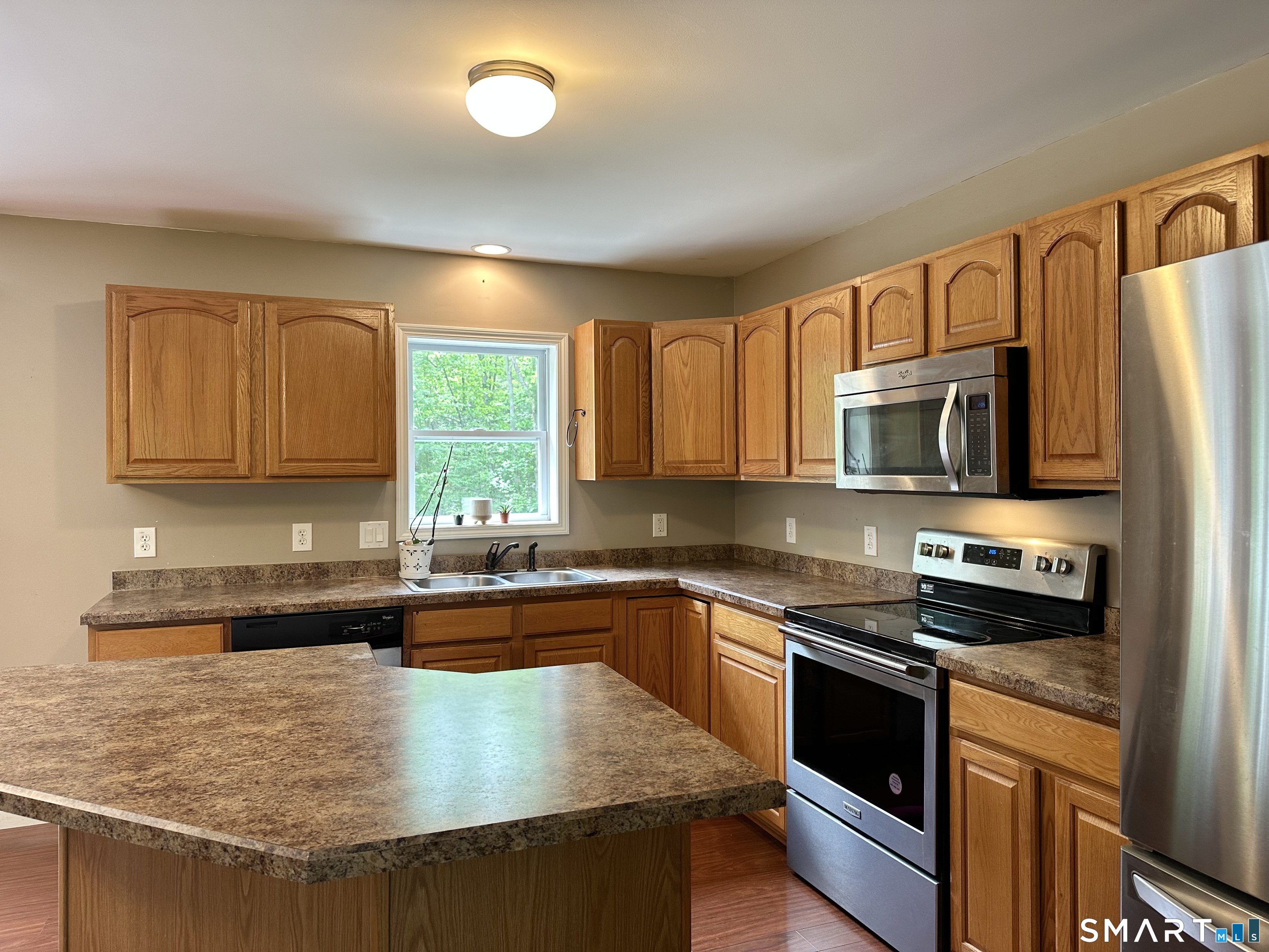 116 Tatnic Hill Road Brooklyn, CT 06234 - Photo 17 of 27 a kitchen with stainless steel appliances granite countertop a sink stove and microwave