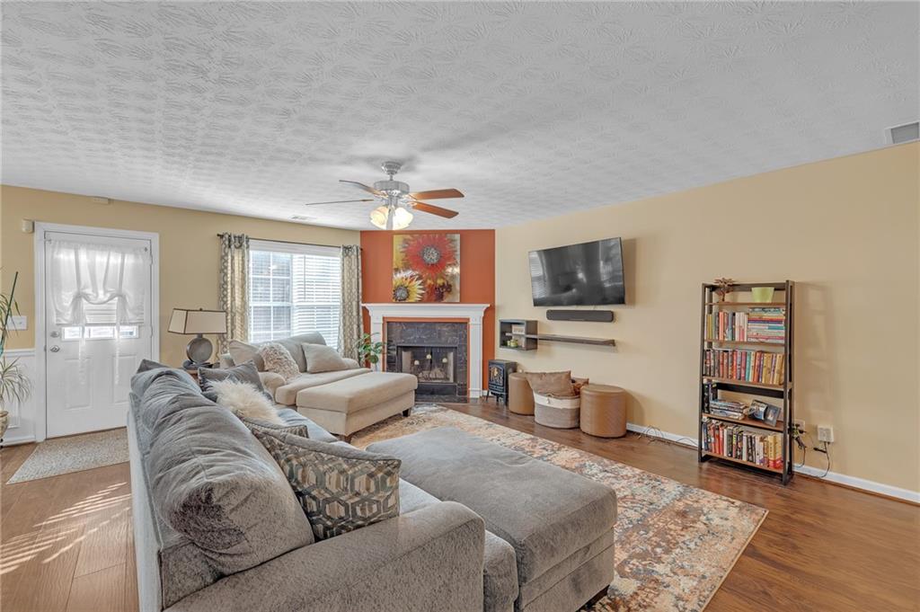 642 Lakes Circle Lithonia, GA 30058 - Photo 7 of 26 a living room with furniture a flat screen tv and a fireplace