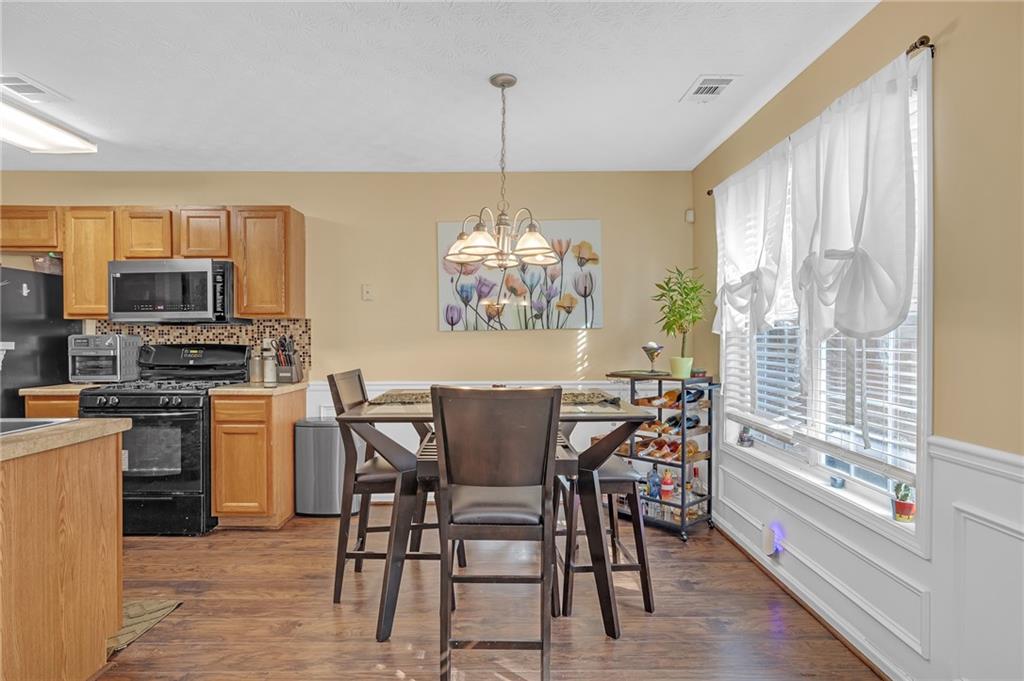 642 Lakes Circle Lithonia, GA 30058 - Photo 10 of 26 a dining room with furniture a chandelier and wooden floor