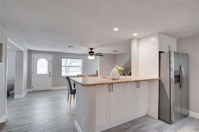 a kitchen with a sink a refrigerator and wooden cabinets