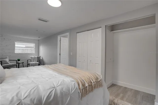 a bedroom with a large bed and wooden floor