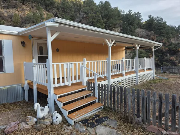 a view of a wooden bench in back yard of a house