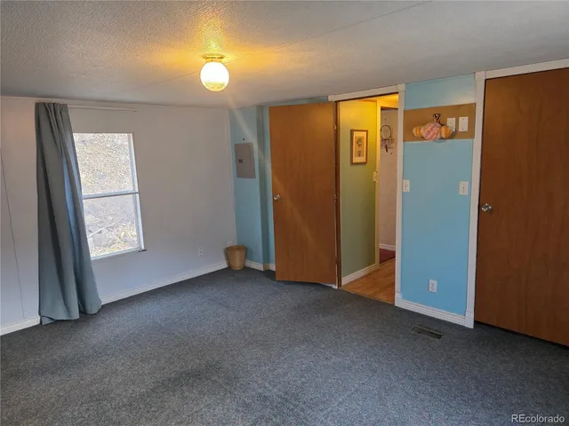 an empty room with closet and windows