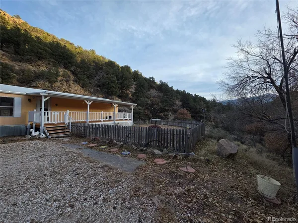 a view of a house with backyard and trees