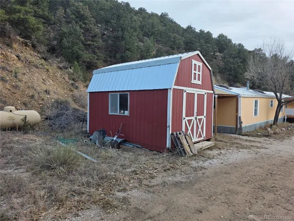 a view of a small house with a yard and roof