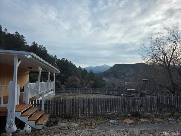 a view of a small house with wooden fence