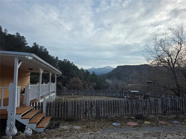 a view of a small house with wooden fence