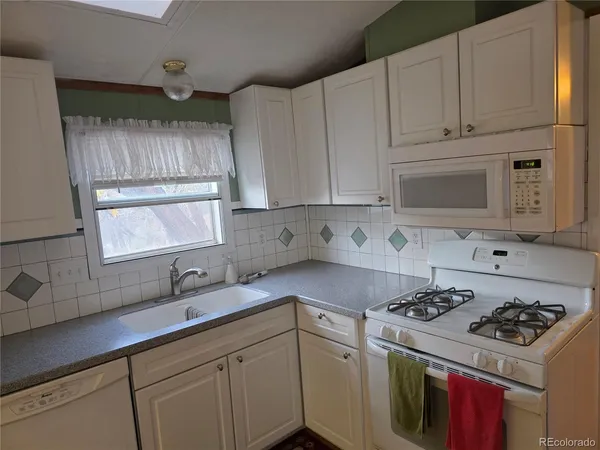 a kitchen with cabinets appliances a sink and a stove