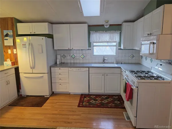 a kitchen with a stove a refrigerator and a cabinets