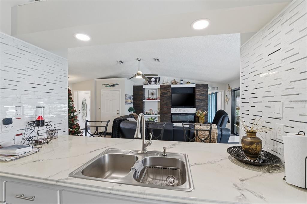 3366 Bluefish Drive Hernando Beach, FL 34607 - Photo 10 of 75 a kitchen with furniture a sink and a flat screen tv