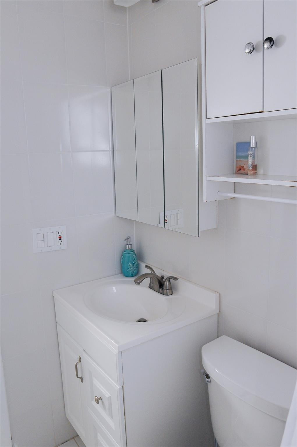 29 Northeast 3rd Street, Unit B Dania Beach, FL 33004 - Photo 16 of 18 a bathroom with a sink a toilet and vanity