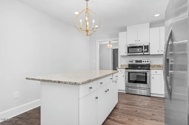 a kitchen with stainless steel appliances a stove a sink and a refrigerator