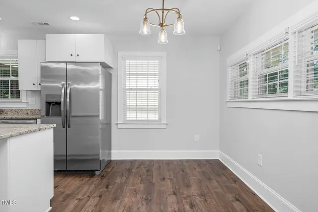 a kitchen with wooden floor and refrigerator