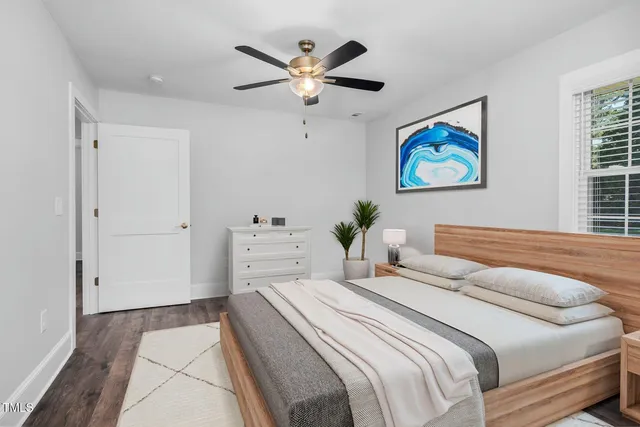 a bedroom with a bed and a painting on the wall