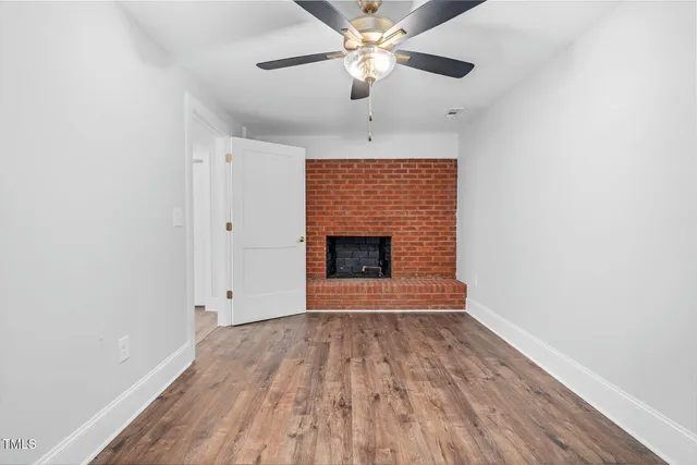 wooden floor in an empty room with a fireplace