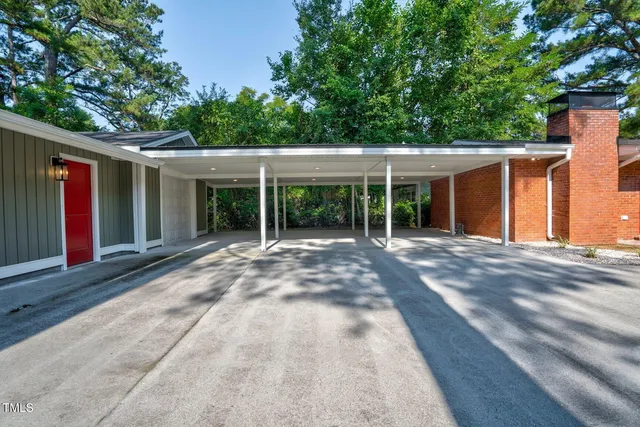 a view of a house with a yard and large tree