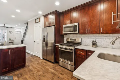 a kitchen with granite countertop wooden cabinets stainless steel appliances and a granite counter tops