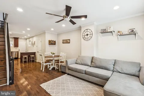 a living room with furniture kitchen view and a window