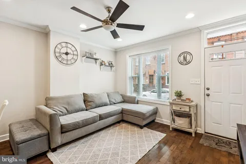 a living room with furniture a clock on wall and a window
