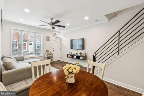a living room with furniture kitchen view and a wooden floor