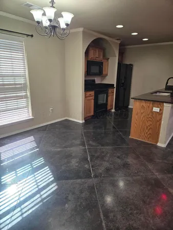 a view of kitchen with granite countertop cabinets and window