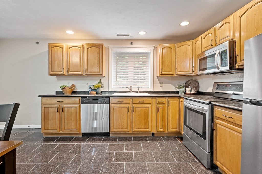 1 Hatfield Street, Unit 3 Worcester, MA 01604 - Photo 11 of 23 a kitchen with stainless steel appliances granite countertop a stove a sink and a microwave