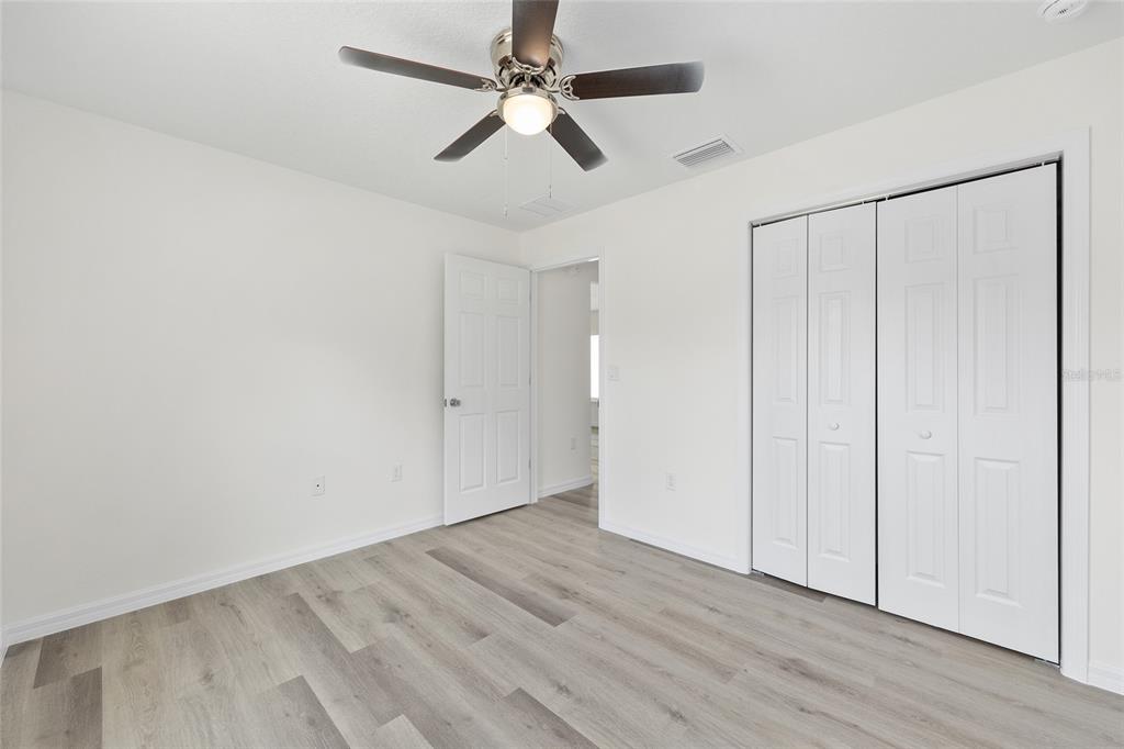 13019 Northeast 7th Loop Silver Springs, FL 34488 - Photo 27 of 35 an empty room with wooden floor closet and fan
