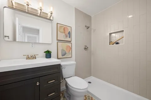 a bathroom with a toilet a sink and mirror