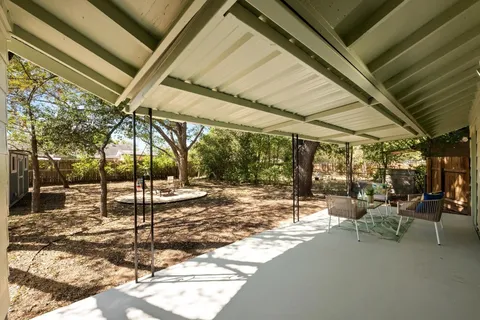 a view of a backyard with table and chairs