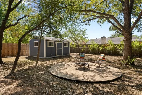 a view of a backyard with table and chairs and a fire pit