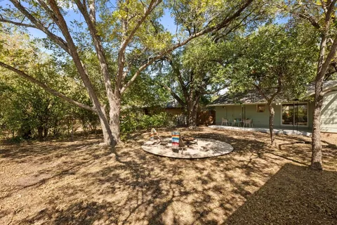 a view of a backyard with table and chairs and a fire pit